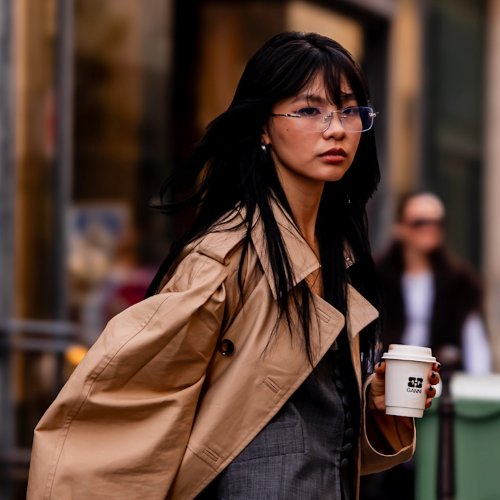 woman wearing tench coat and glasses 