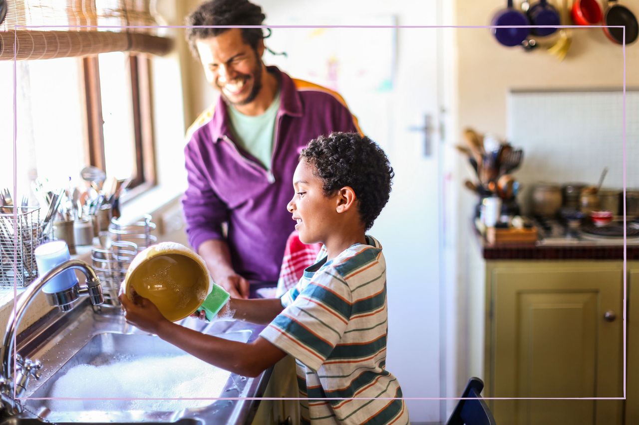 A young boy helping his dad with washing up