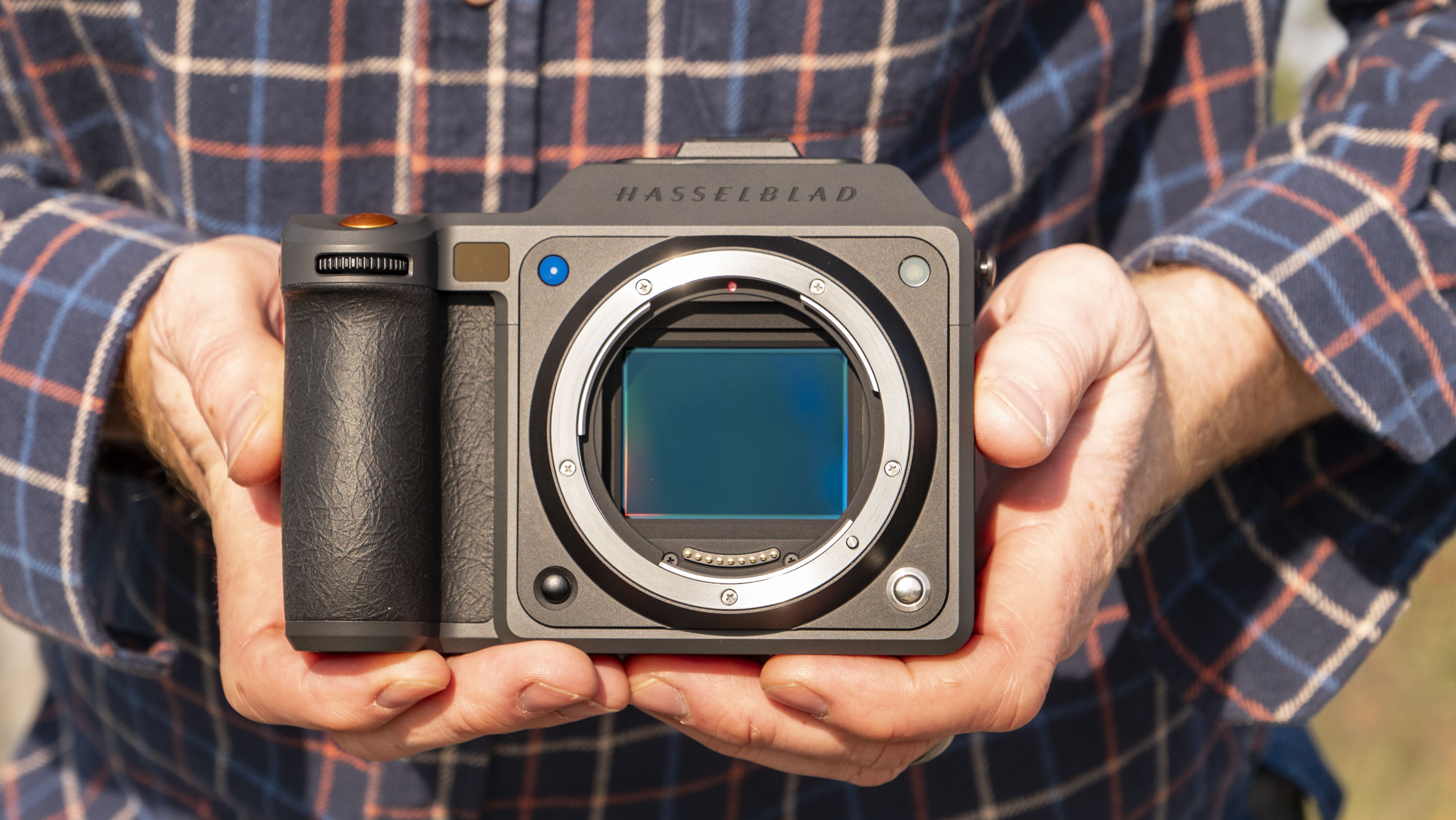 Hasselblad X2D II 100C camera in the hand, outdoors at first light
