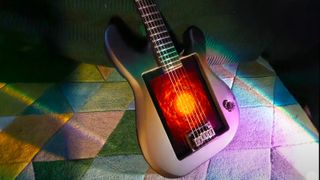 A photo of a guitar with an iPad in the centre on a colourful background