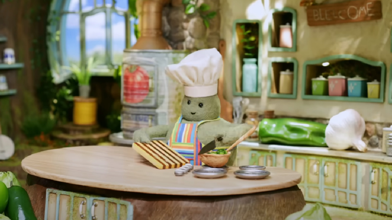 Tiny Chef cutting up something on a cutting board.