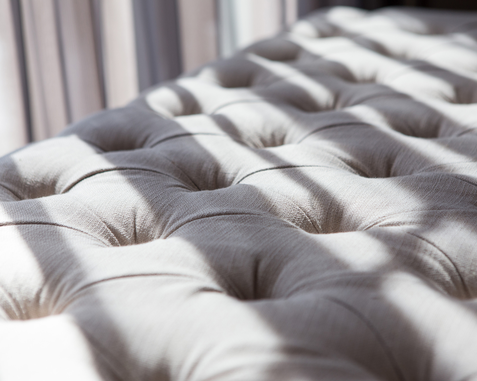 A quilted button-backed mattress drying in sunlight