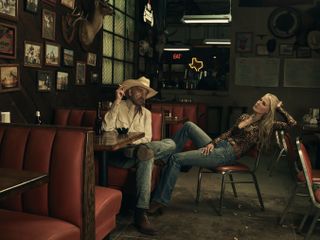 Billy Bob Thornton and Ali Larter as Tommy and Angela Norris lounging in a bar in Landman.