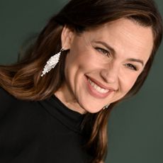 Actress Jennifer Garner in front of dark green background