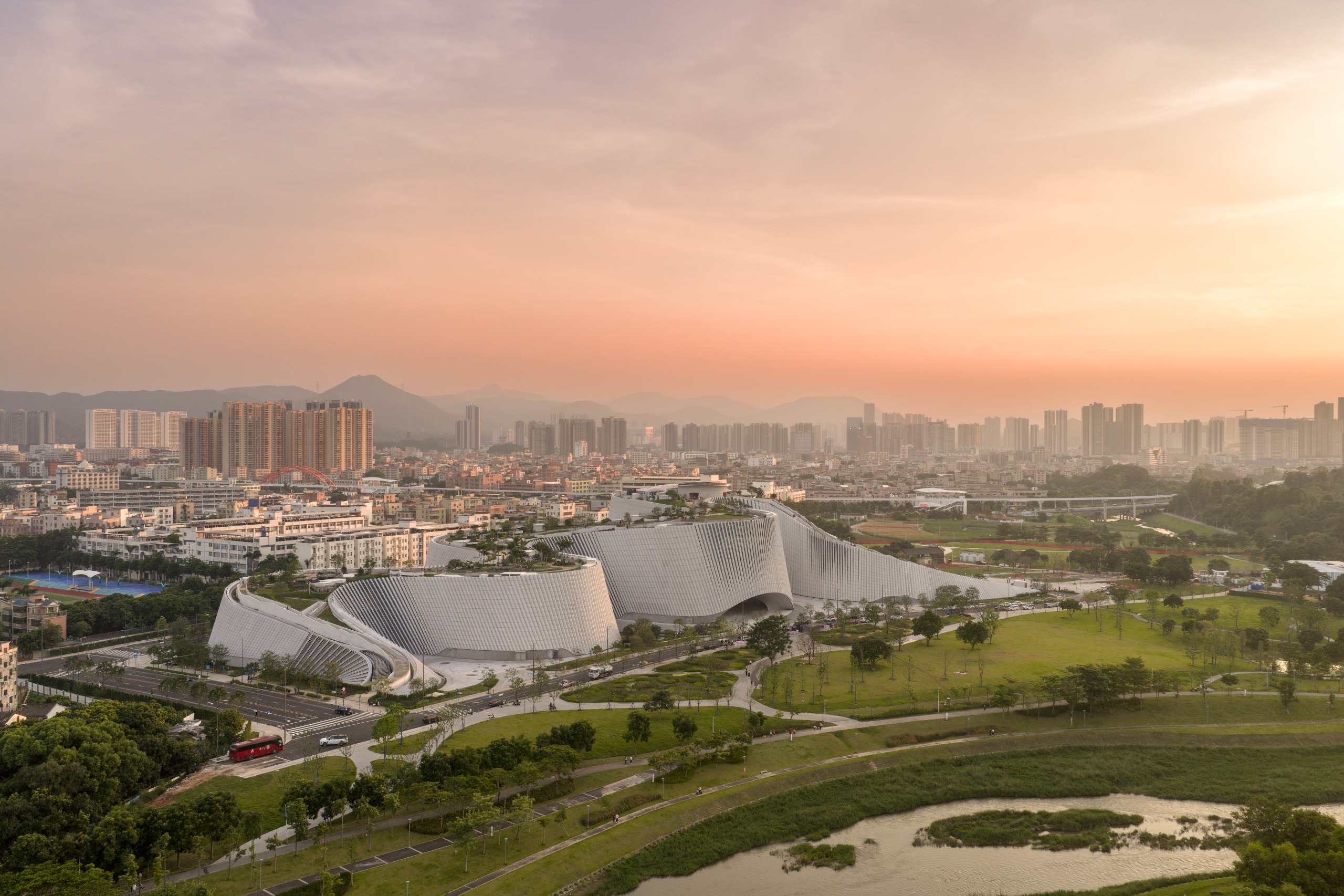undulating forms of the Shenzhen Natural History Museum by 3XN, B+H Architects and Zhubo Design in a green park