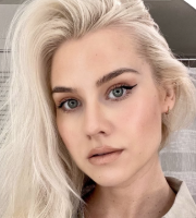 a blonde woman with blue eyes and dark eyeliner