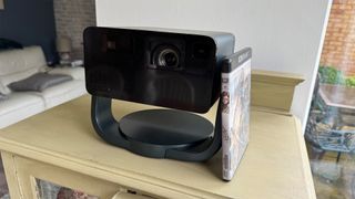 Epson EF-22 portable projector on wooden table with Blu-ray disc propped against it