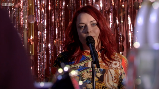 Shona McGarty sings on stage as Whitney Dean in EastEnders