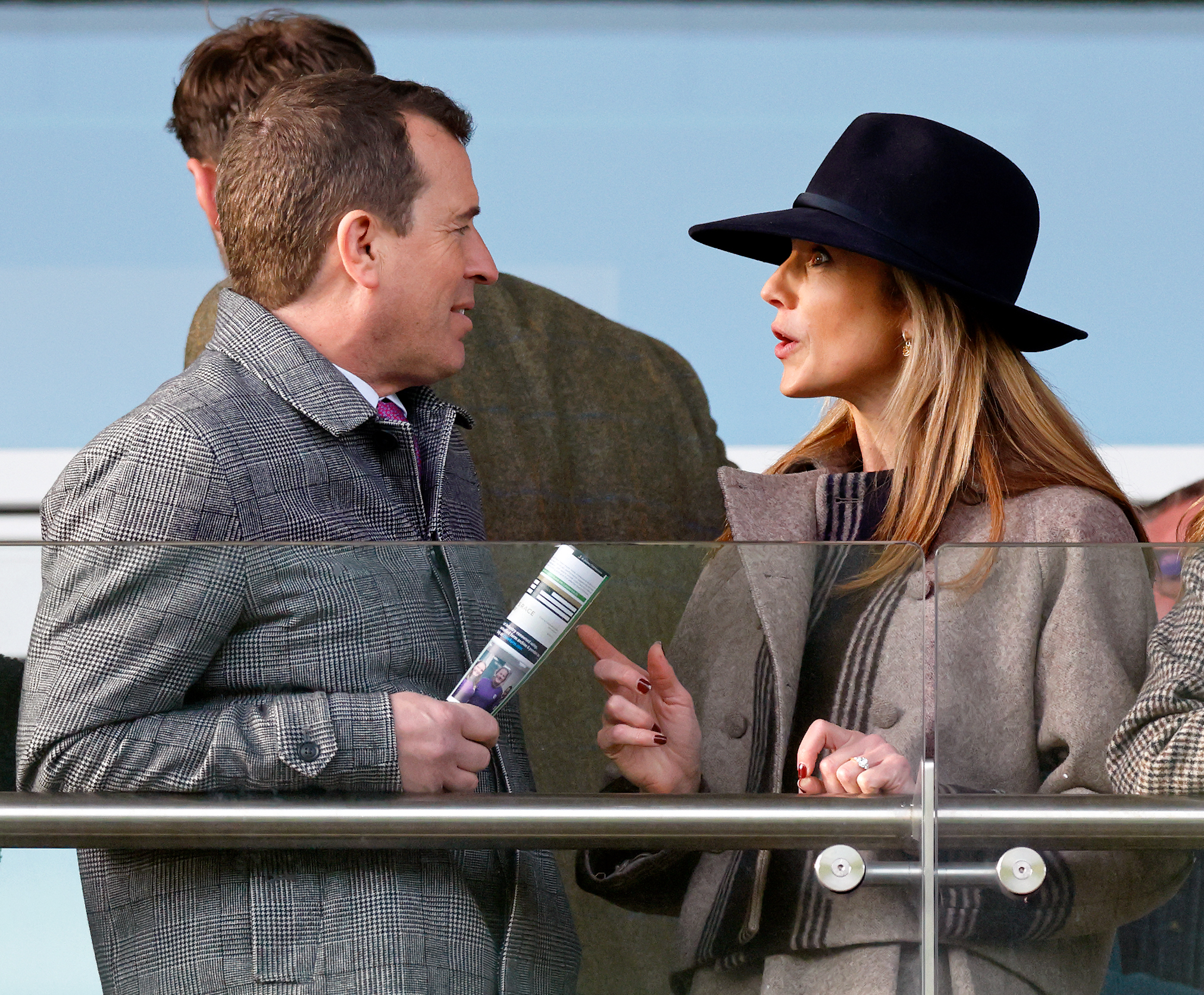Harriet Sperling wearing a floppy hat and brown coat talking to Peter Phillips