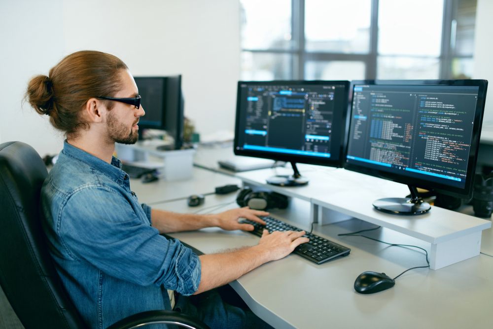 Man at a desk coding software