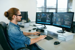 Man at a desk coding software
