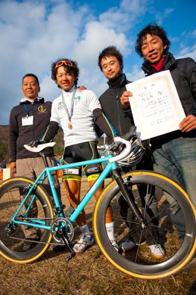 Takenouchi Yu takes a picture with his support stuff 9794 Takenouchi Yu (Team Eurasia-Fondriest bikes) in the champion jersey