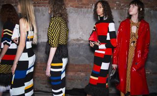 Models with bold colour-blocked stripes knit dress