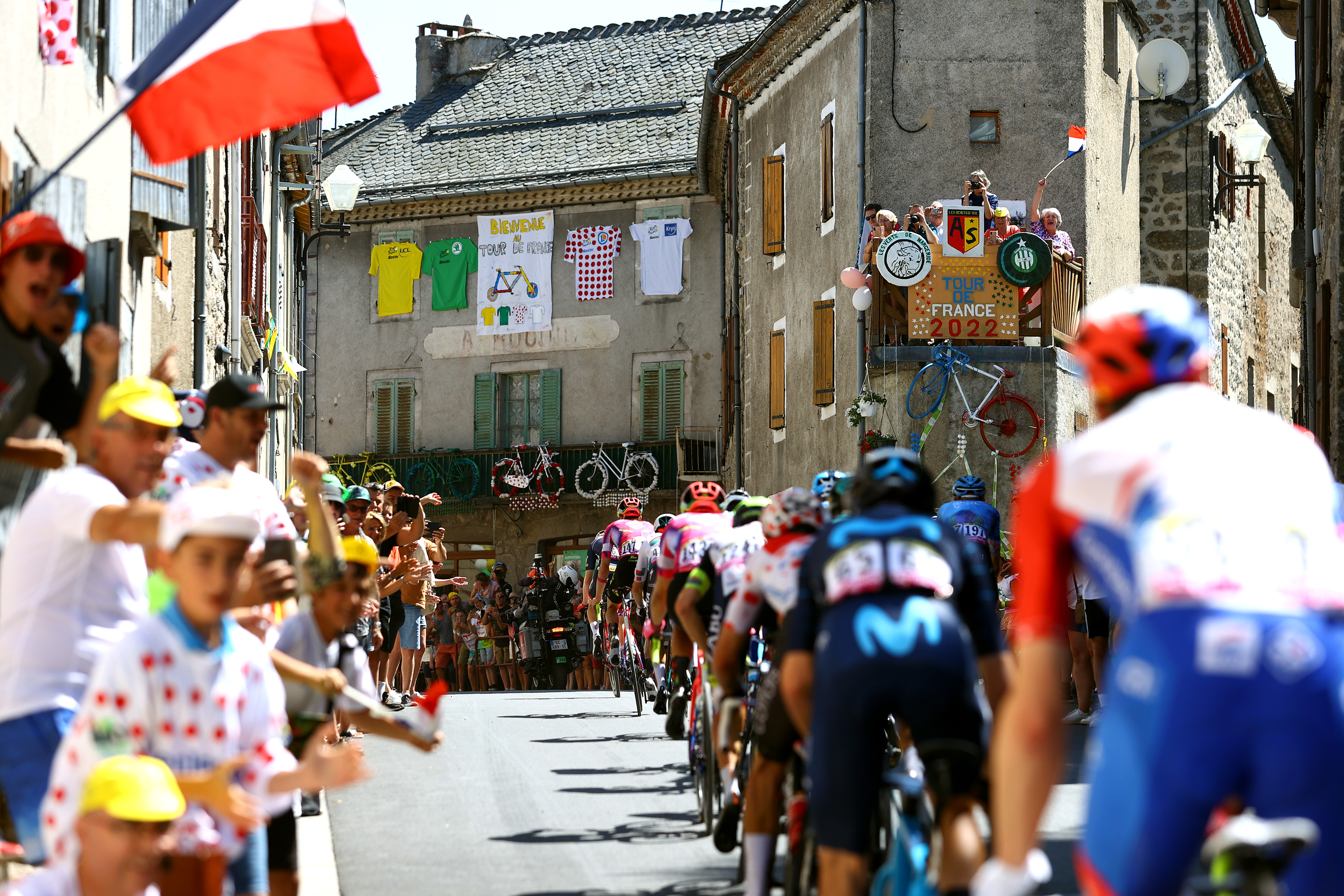 The peloton passes through a French village at the 2022 Tour de France