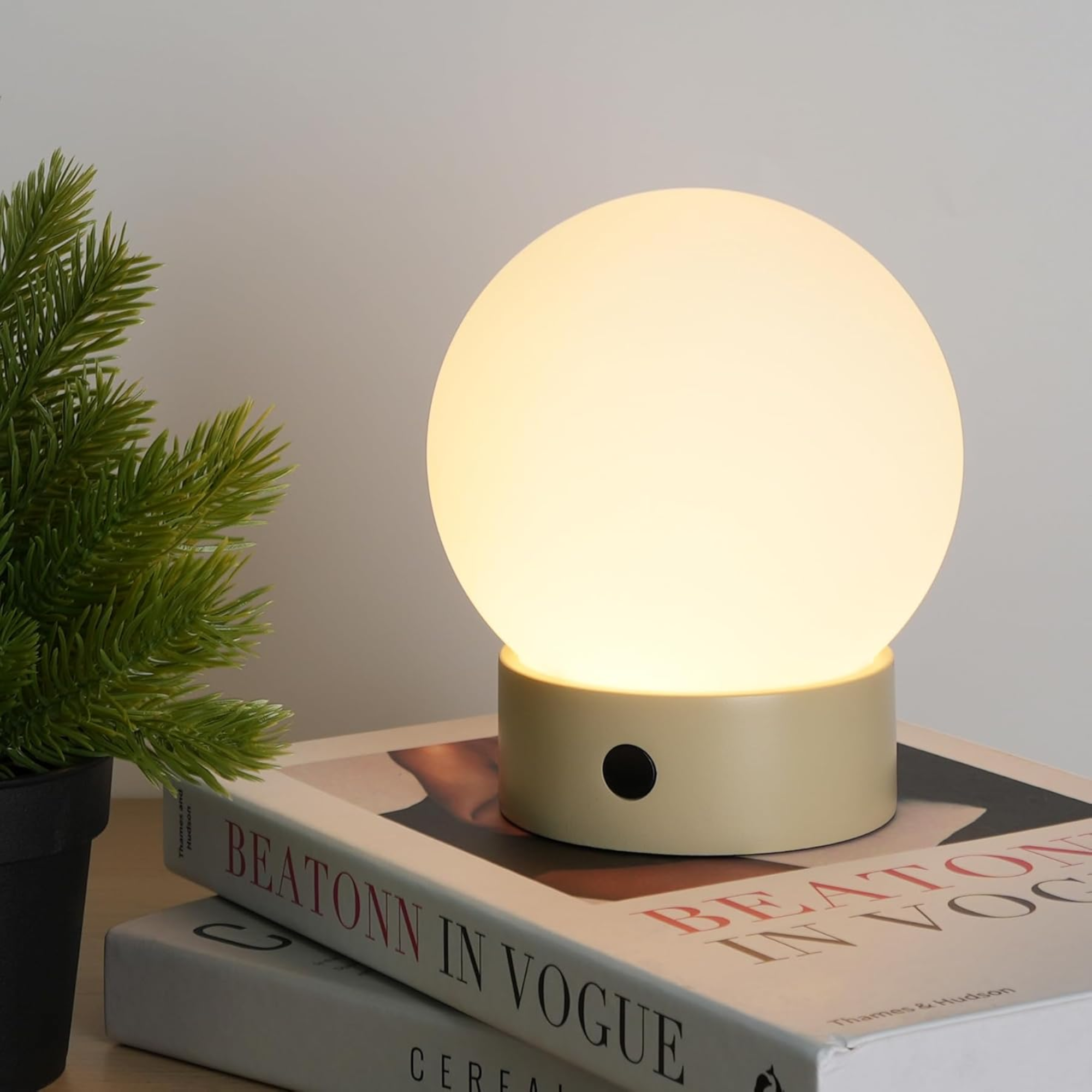 a spherical shower lamp with a cylindrical base and a black button
