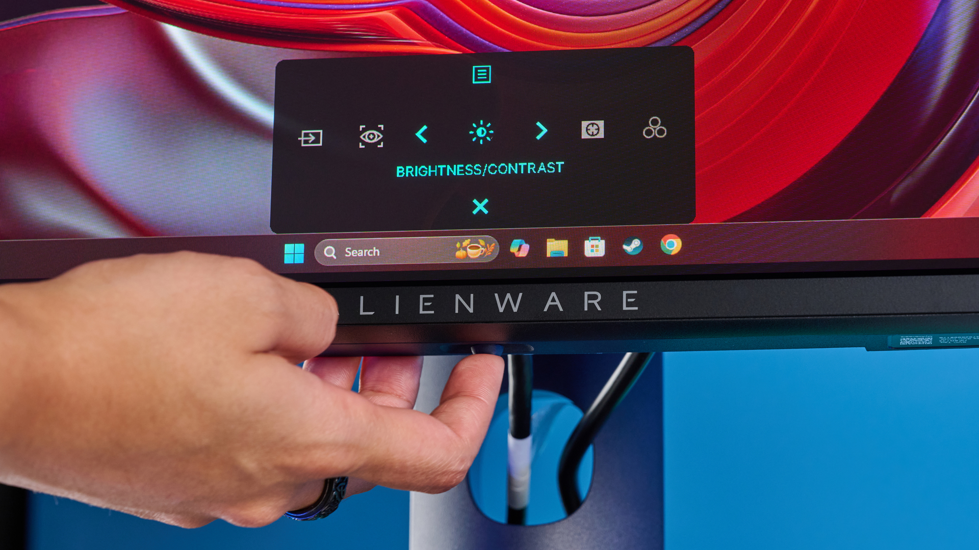 Alienware AW2725D on a desk against a blue background