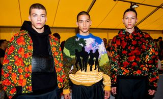 Three male models wearing highly patterned jackets and sweaters