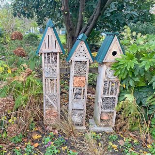 Three towering bug hotels on a garden walk