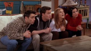 From left to right: Joey, Chandler, Rachel and Monica sitting on a couch looking up.