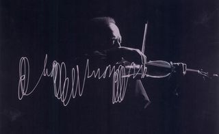 Black and white image of Jascha Heifetz playing the violin