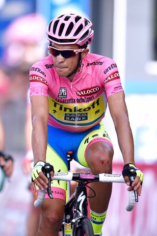 Alberto Contador crosses the line after being caught up in a crash and dislocating his shoulder