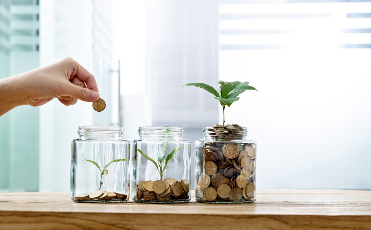 Woman putting a coin in a jar, with a plant growing out of the top