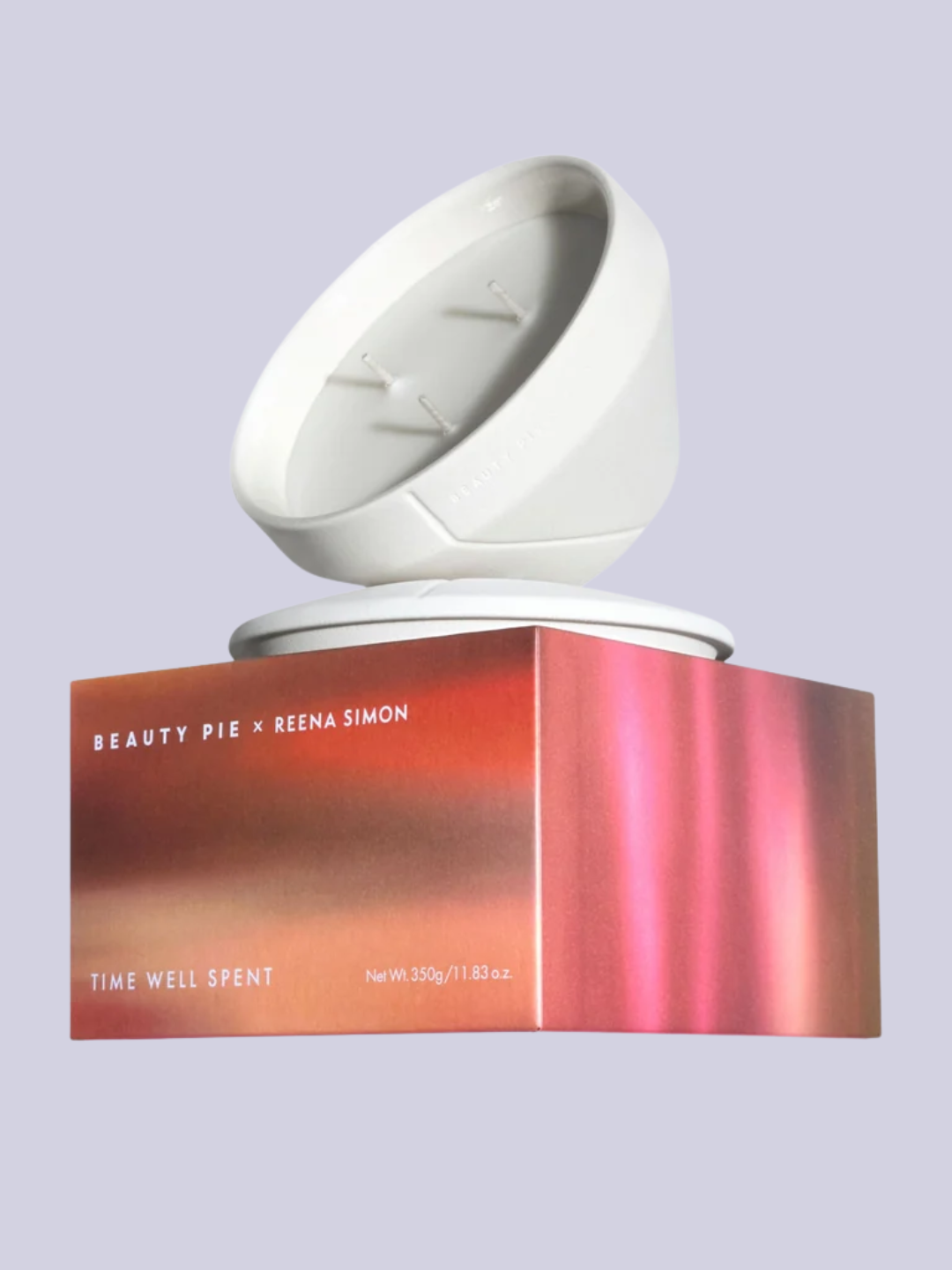 A scented ceramic candle with a lid on a colorful box from Reena Simon x Beauty Pie