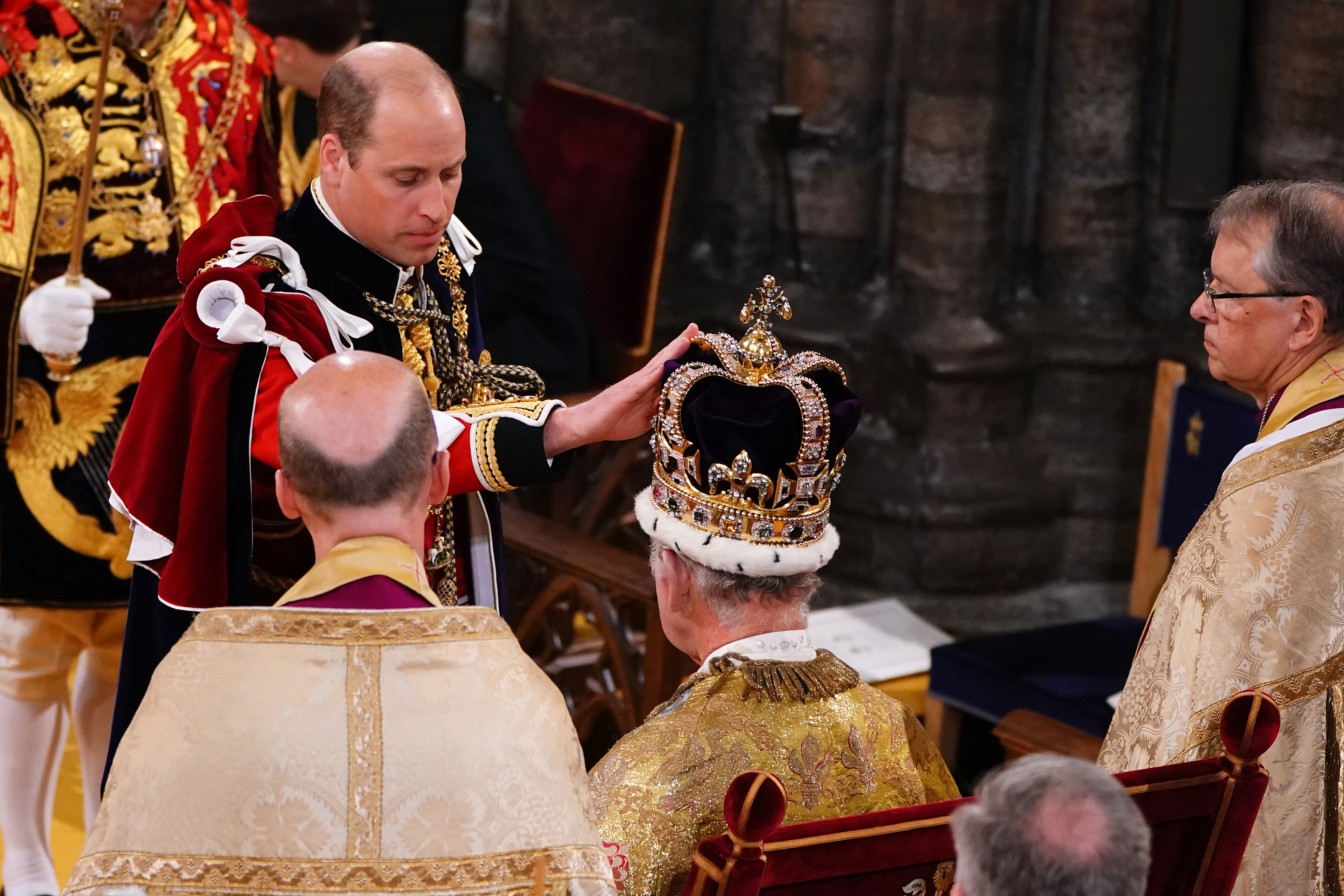 Prince William placing his hand on King Charles's crown at his coronation