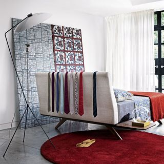 bedroom with white wall bed with colourful ties on head board and designed frame