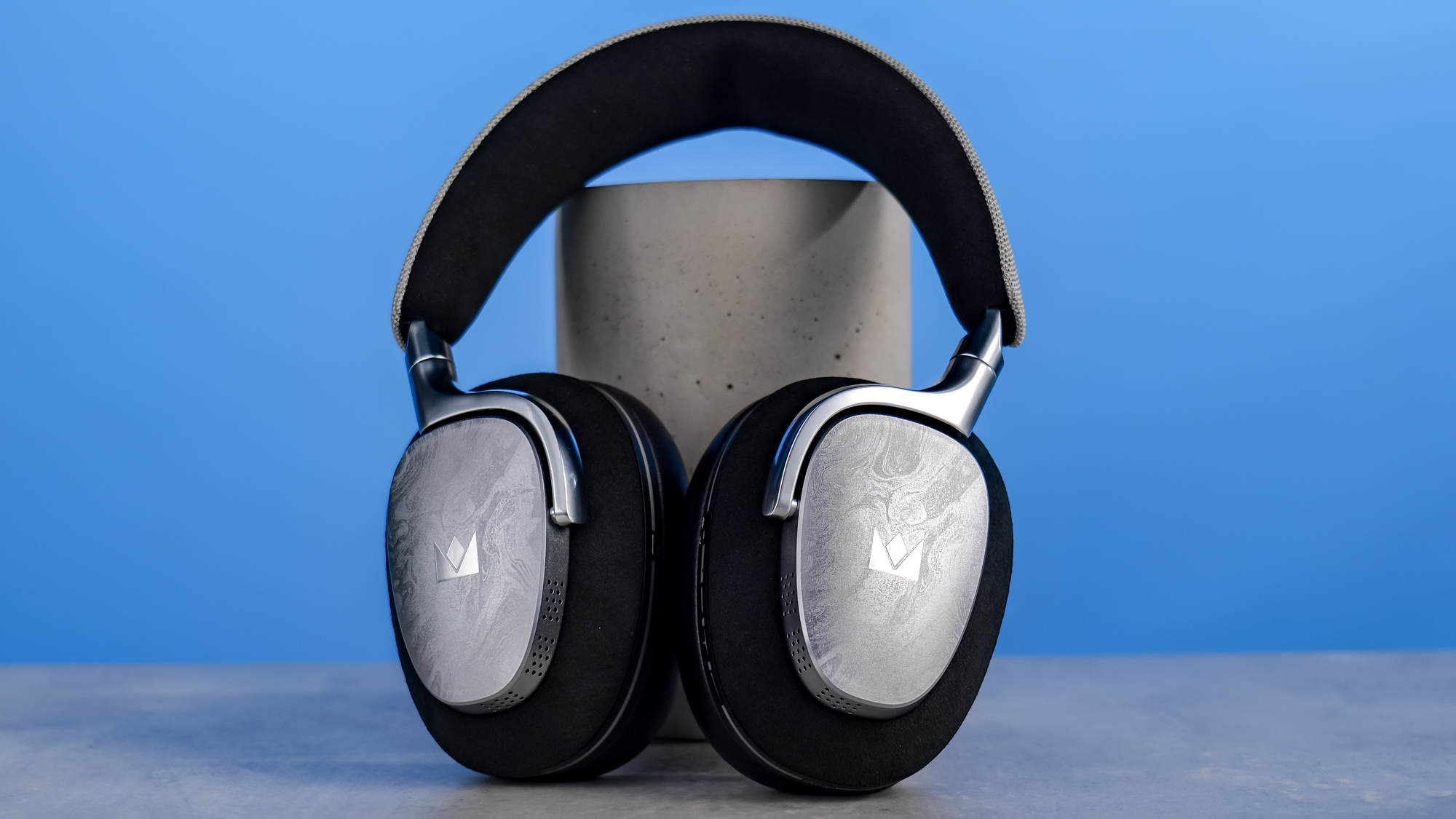 The Noble Audio FoKus Artemis on a stone surface, propped up on a plinth, against a blue background