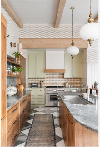 Kitchen with cooker hood and lighting over island and rug running center