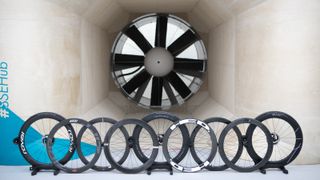 Nine front road bike wheels sit in front of the fan within a wind tunnel