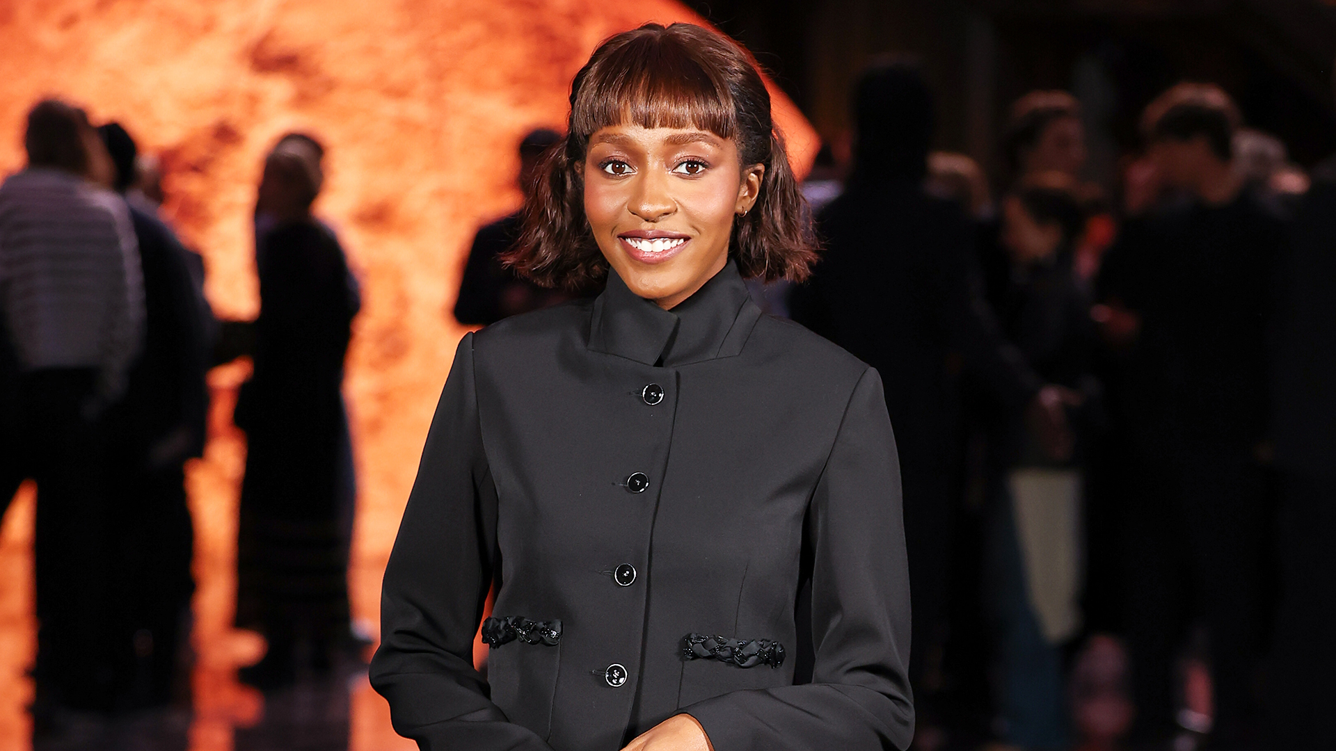 Ayo Edebiri wearing a black blazer, dark-wash jeans, and pumps to the Chanel S/S 26 show