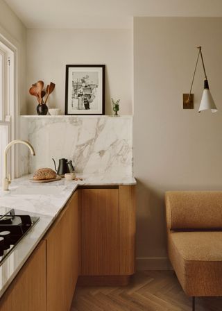 A small kitchen with marble counters and shelving