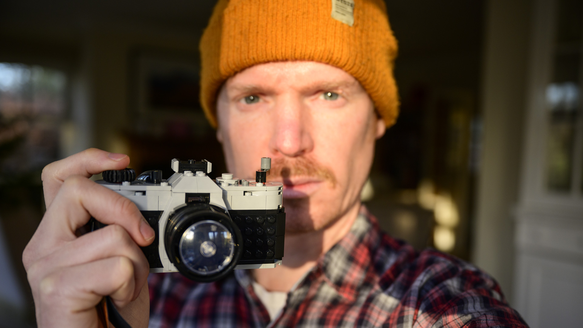 Reviewer holding the complete Lego Retro camera in golden hour light