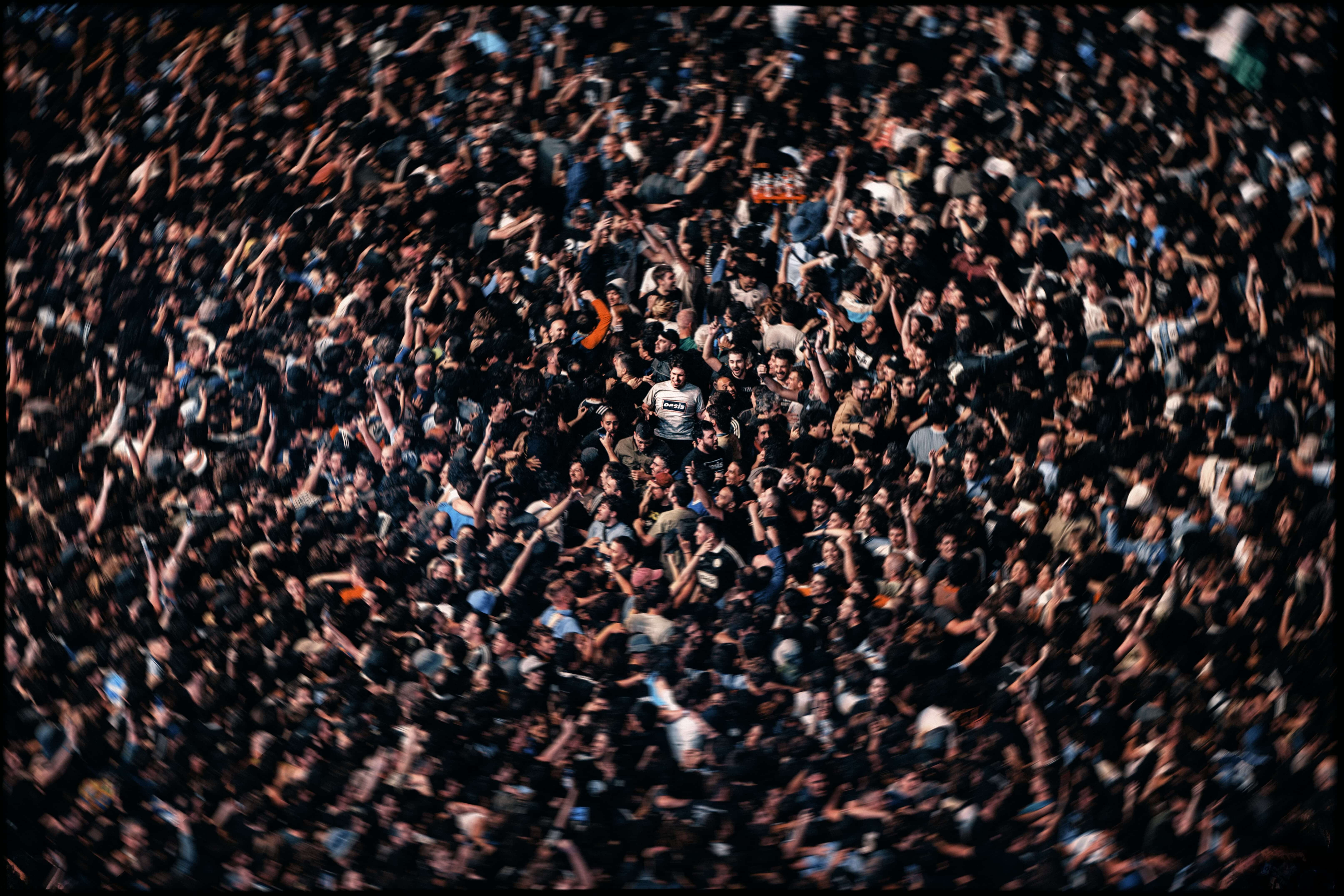 Oasis fan in muddle of crowd.