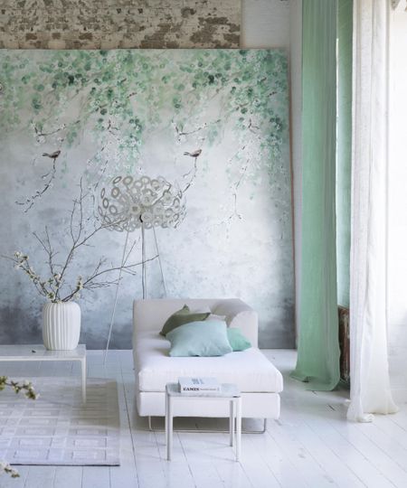 green and white living room, modern and minimalist with white floor boards, white chaise long, side tables, green floral mural, green drapes