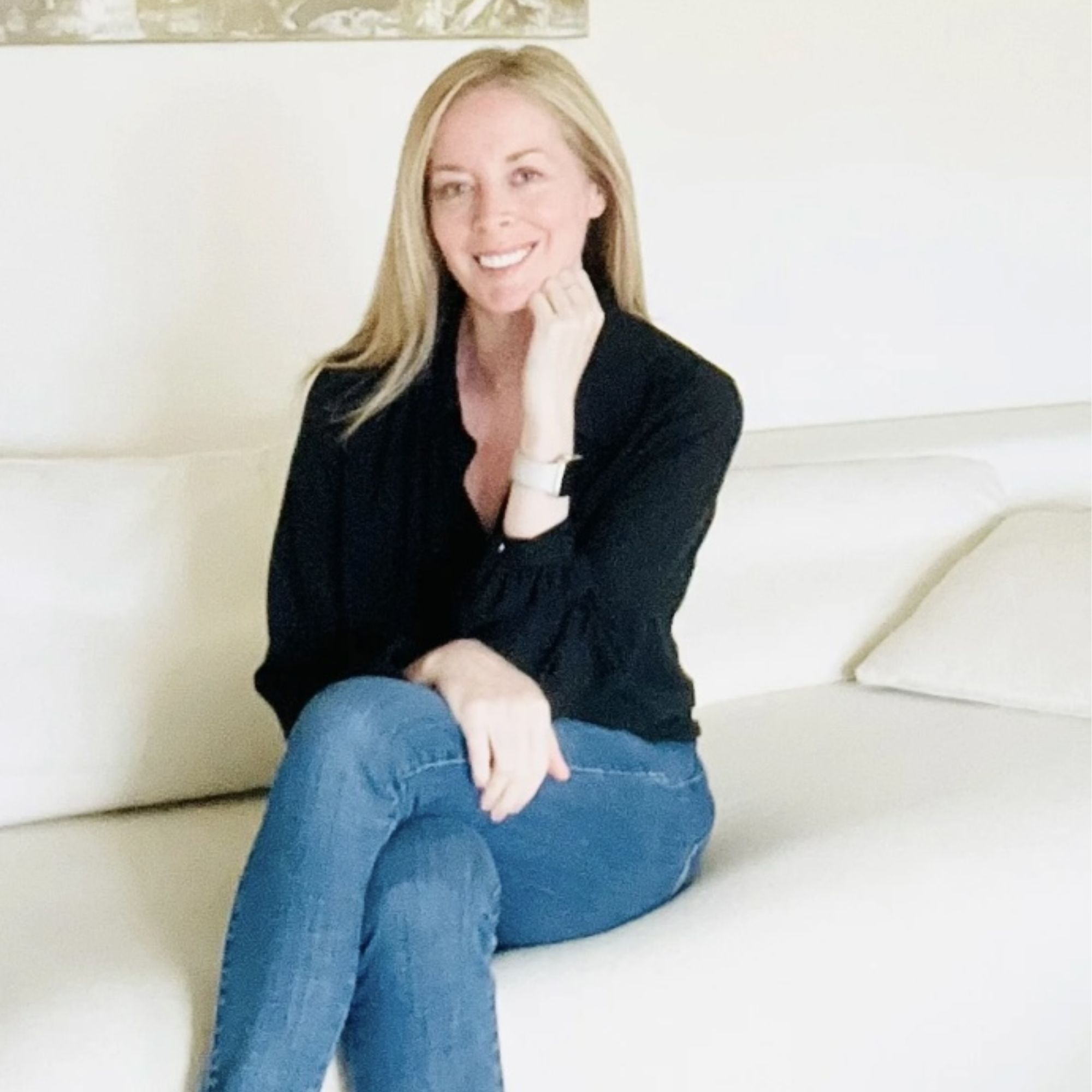 A headshot of Emilia Guasconi wearing blue jeans and a black shirt, against a white background