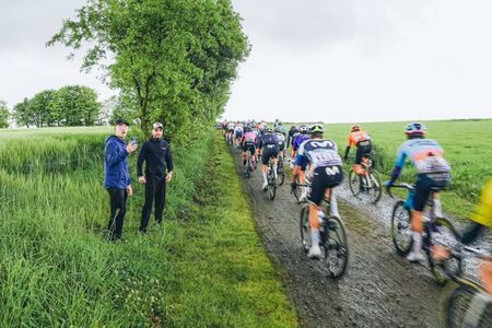 Riders pass by fans on a ribin dirt sector at the 2025 Tro-Bro L&eacute;on