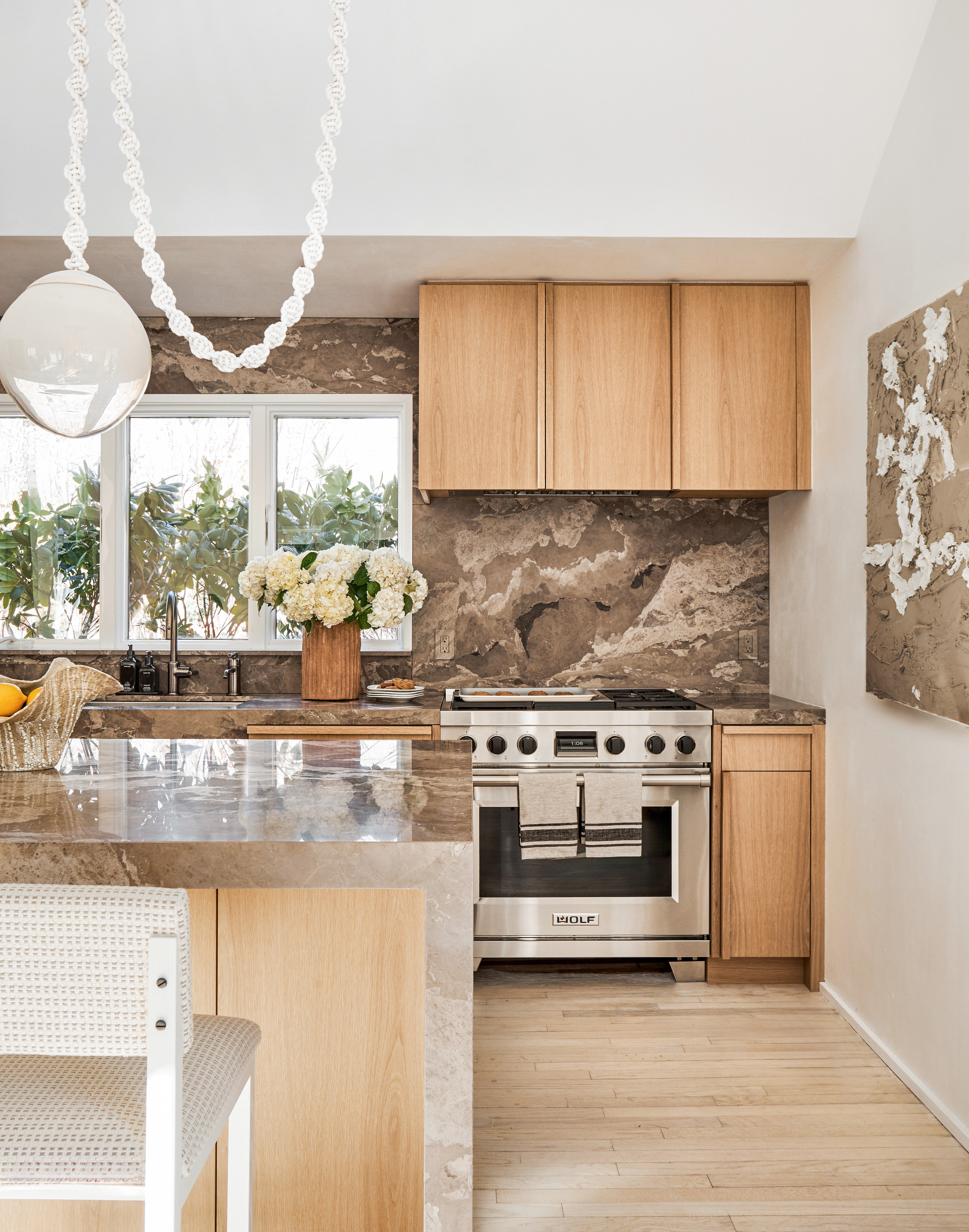 Wood kitchen with brown stone countertop and splashback