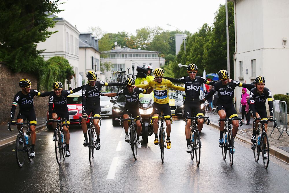 Team Sky ride arm in arm to the finish in Paris.