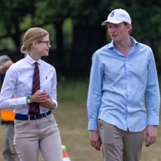 Lady Louise Windsor standing next to Felix da Silva-Clamp in a field