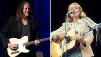 Robben Ford [left] wears a dark suit jacket and v-neck t-shirt as he plays a blonde Telecaster onstage. Photographed in 1975, Joni Mitchell [right] plays her Martin dreadnought live onstage at Wembley Stadium.