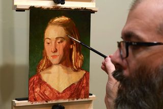 An artist painting a portrait in oils