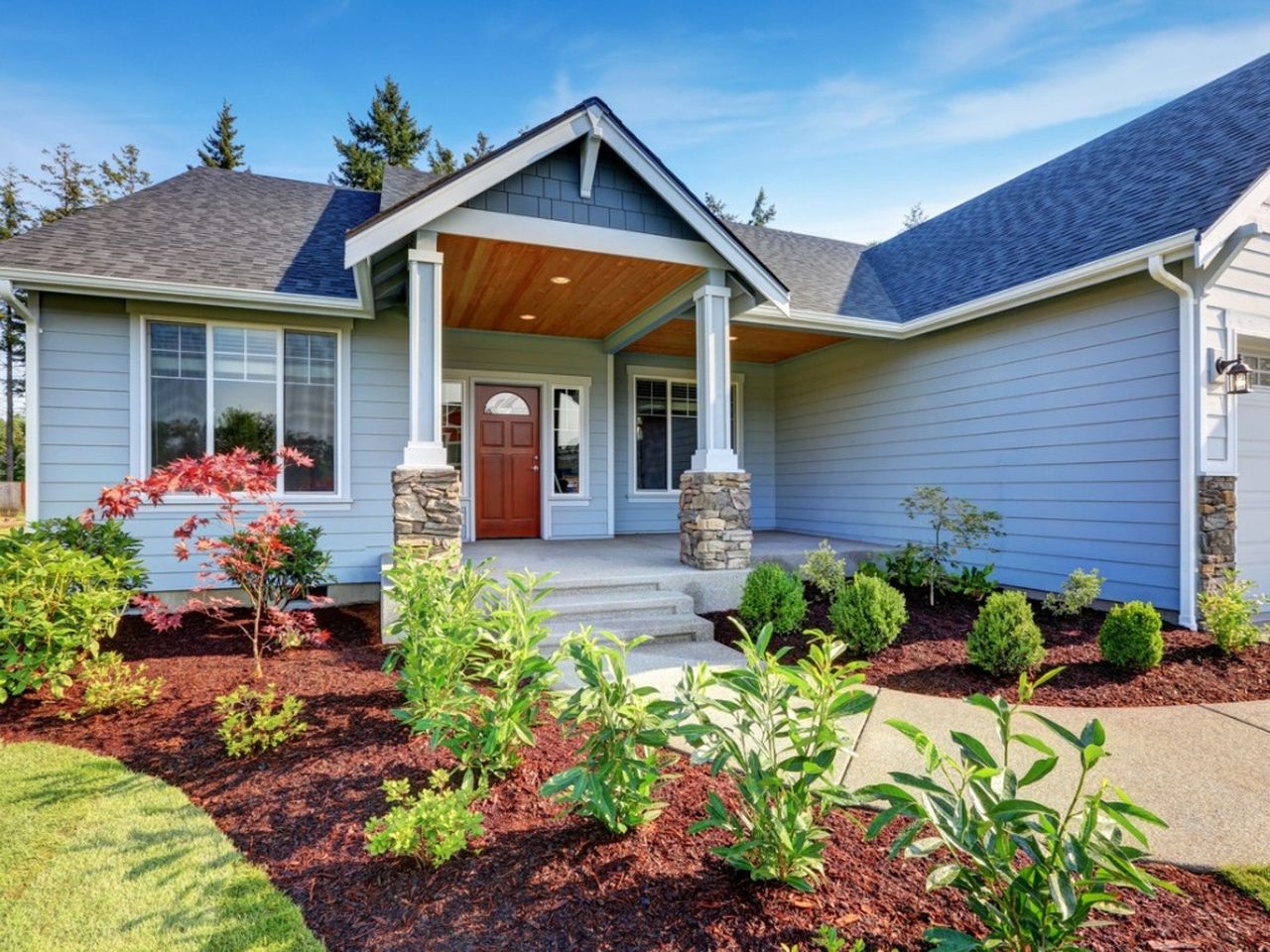 An orderly garden in front of a blue house