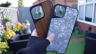 Hand handing Mous Limitless 5.0 shockproof case in a garden