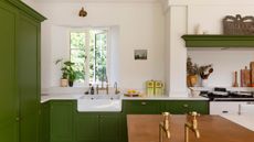 A kitchen with green cabinets and white countertops