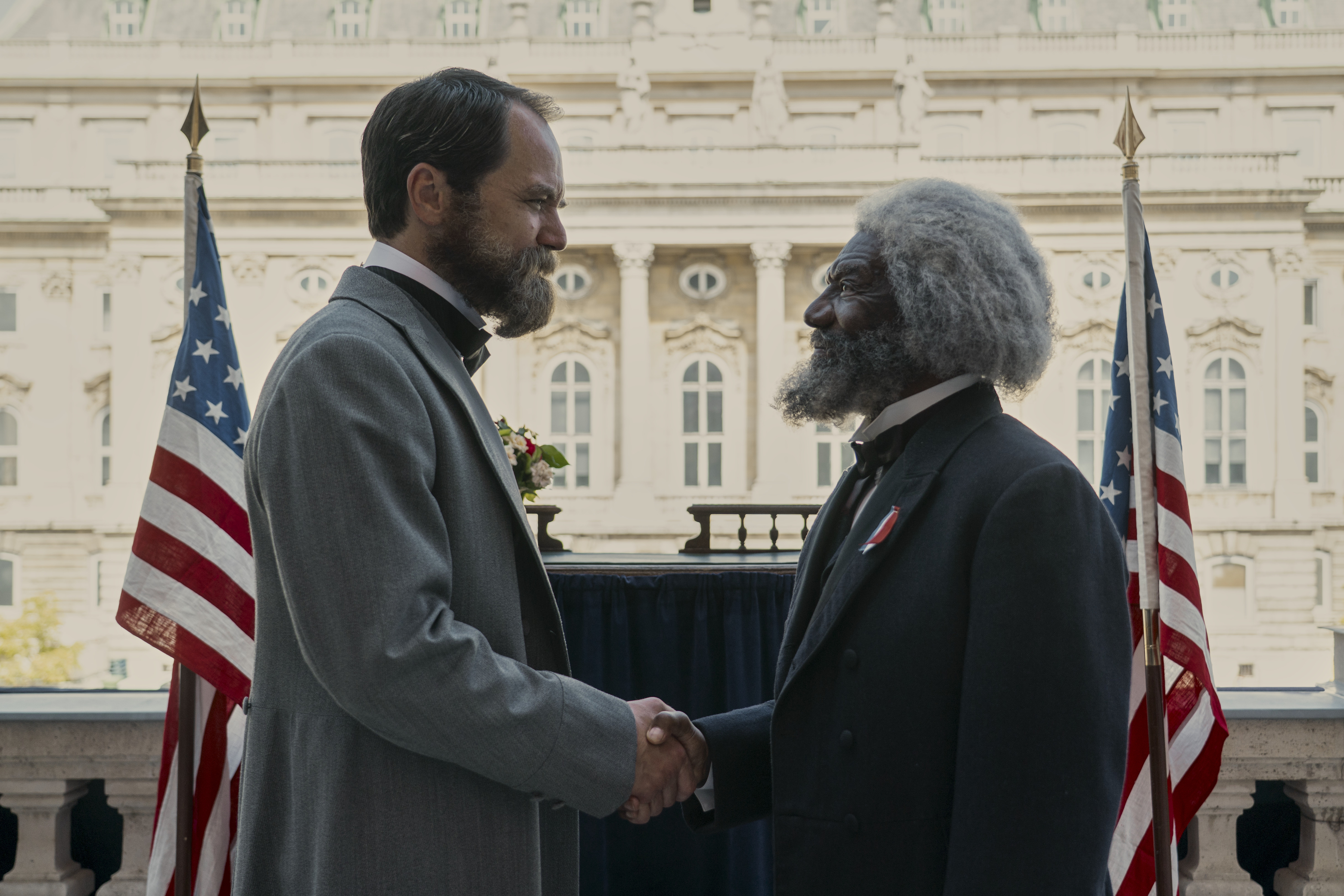 Michael Shannon as James Garfield and Vondie Curtis-Hall as Frederick Douglass shaking hands outside of the white house in the tv show death by lightning