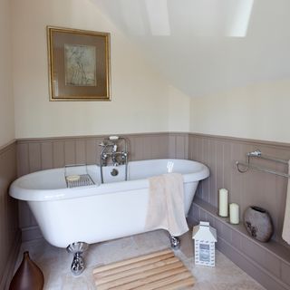 attic bathroom with panelled walls and white bathtub
