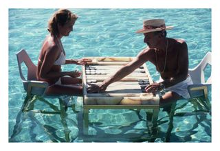 Carmen Alvarez enjoying a game of backgammon with Frank 'Brandy' Brandstetter in a swimming pool at Acapulco